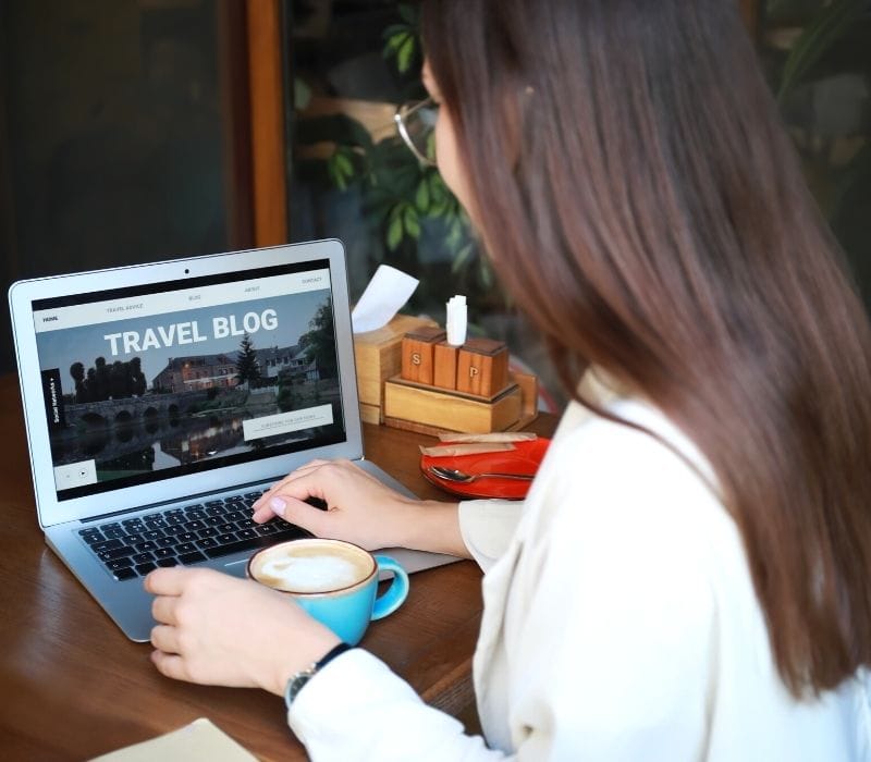 Woman working on her travel blog on her laptop. 